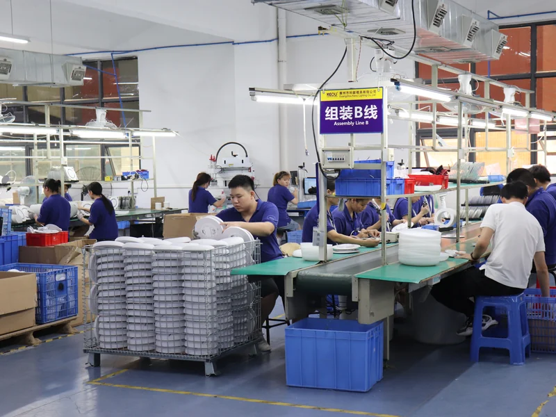 Workers produce LED panel lights on the assembly line at the KEOU lighting factory