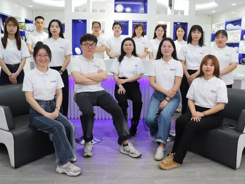 KEOU Lighting sales team group photo inside lighting showroom with various LED light fixtures